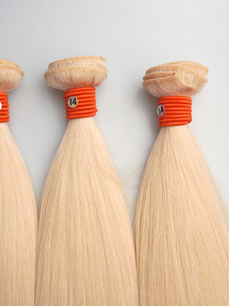 Close-up on the base of three 613 bundles showing neat weft construction and aligned cuticles starting from the root