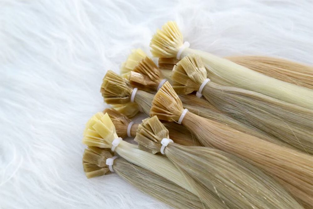 Assortment of blonde and brown Flat-Tip Extensions, focus on tips.