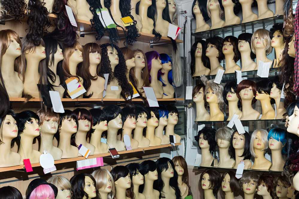 Mannequins showcasing blonde and brunette style wigs in a hair salon