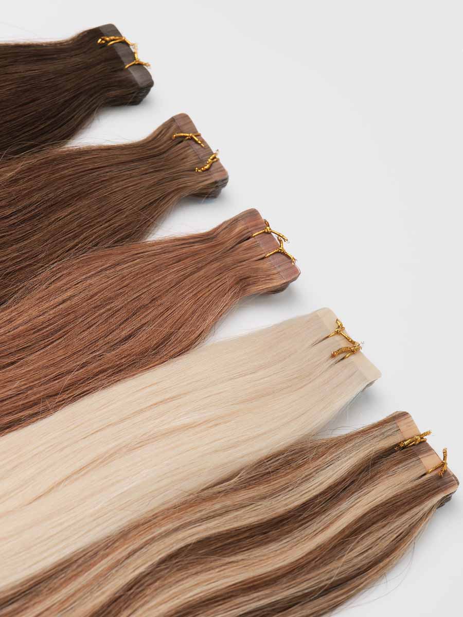 Angled view of all five colored straight tape-in extension shades lined up together.