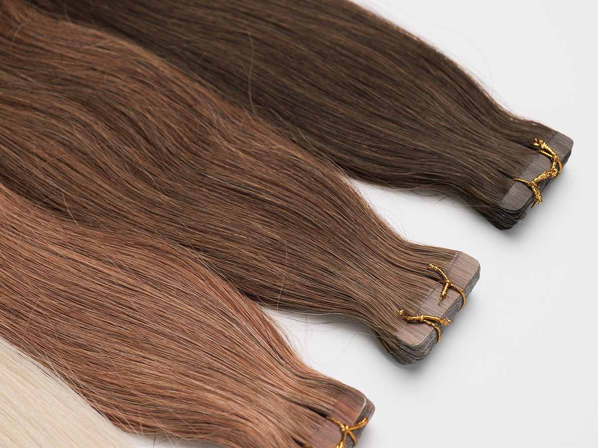 Detailed image of colored straight tape-in extensions in shades 2, 4, and 30, showing tone contrast.