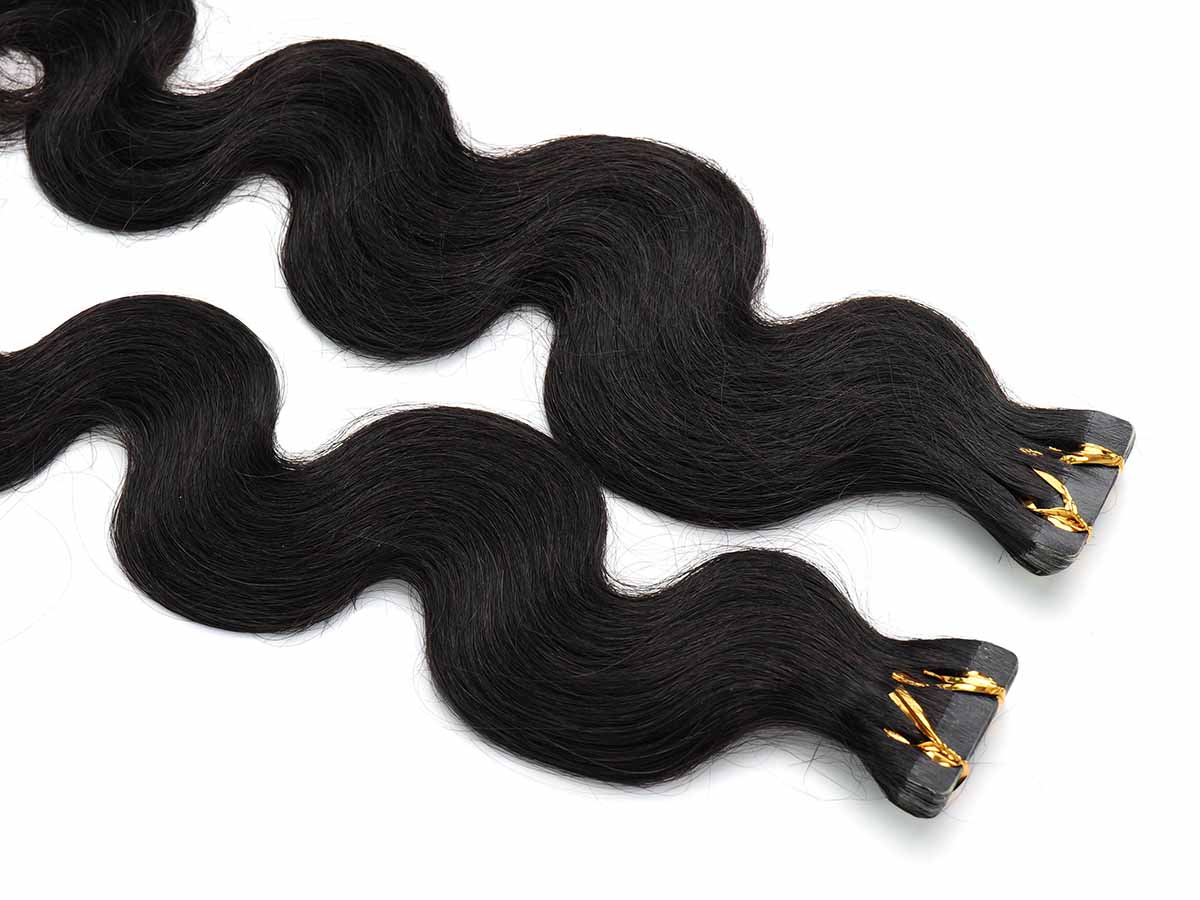 Top-down view of body wave tape-in extensions on a white background, highlighting the tape tabs for application.