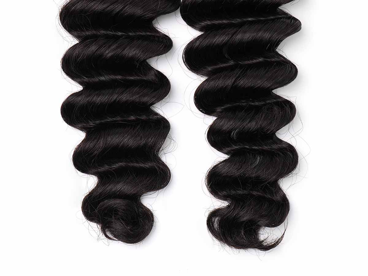 Detail shot of the ends of deep wave tape-in extensions, highlighting the wave pattern at the tips.