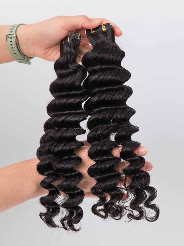 Black Line deep wave tape-in extensions held in hand, laid straight to show length and wave pattern.