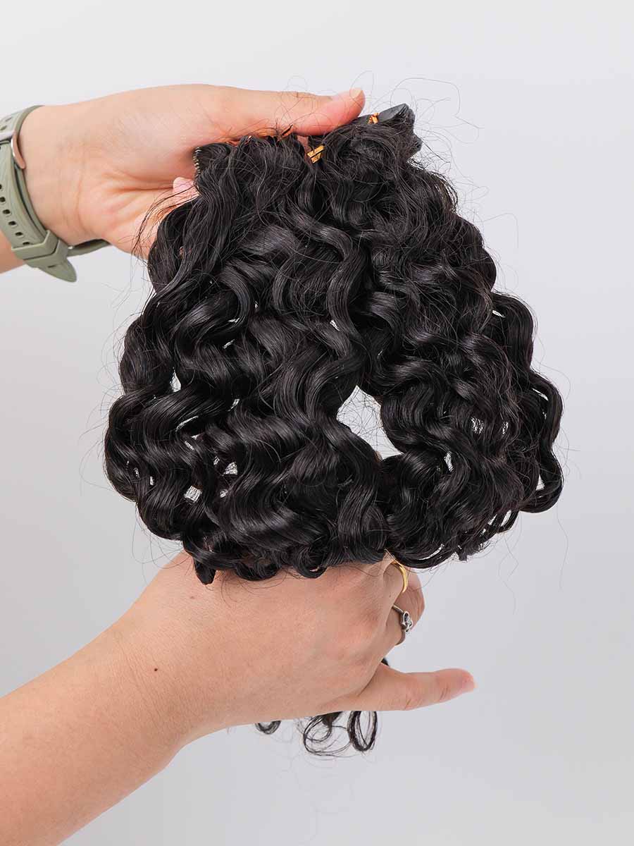 Two sets of water wave tape-in extensions held with a natural curve, showing wave definition.