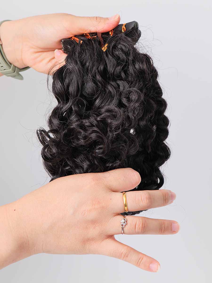 Water wave tape-in extensions with ends folded upward, clearly showing curl pattern at the tips.