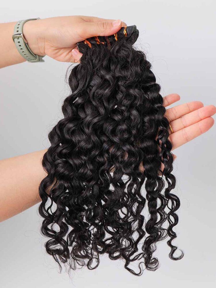 Two sets of water wave tape-in extensions held in hand, prepared for shipping.